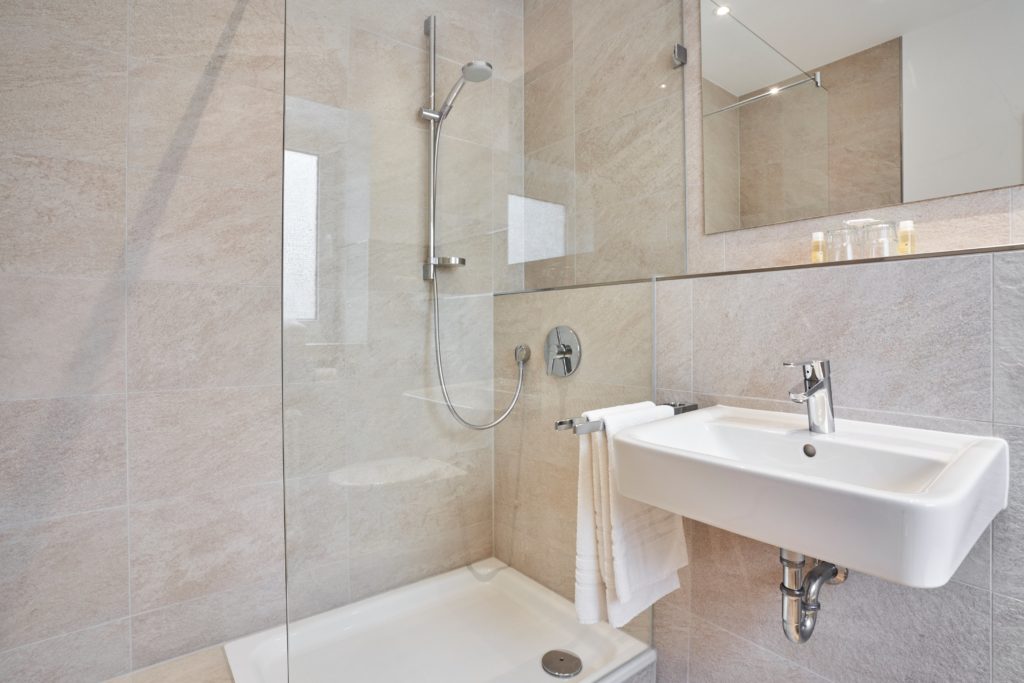 Badezimmer mit Dusche und Waschbecken im Hotel Goldener Engel Speyer