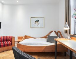 Einzelzimmer mit Bett, Schreibtisch, Fernseher und Sitzecke im Hotel Goldener Engel Speyer